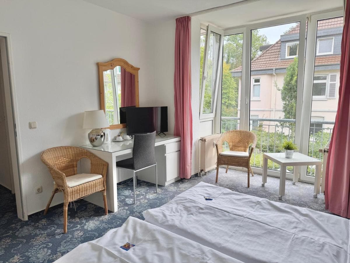 Schreibtisch mit Fernseher und Sitzecke am Fenster